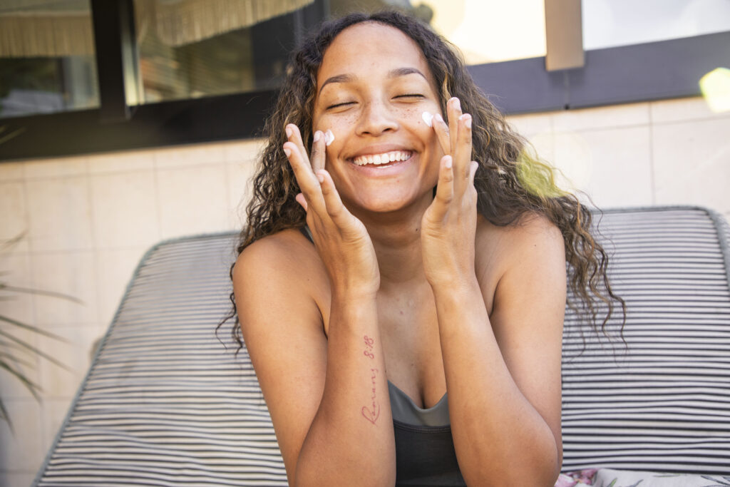 Smiling woman with glowing skin, representing improved skin hydration, elasticity, and collagen after Astrion® use.